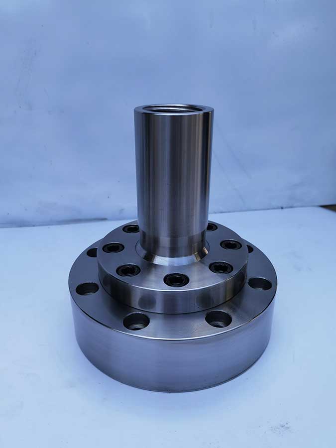 Custom forged and CNC machined spherical bearing component for high-rise building damper assembly.