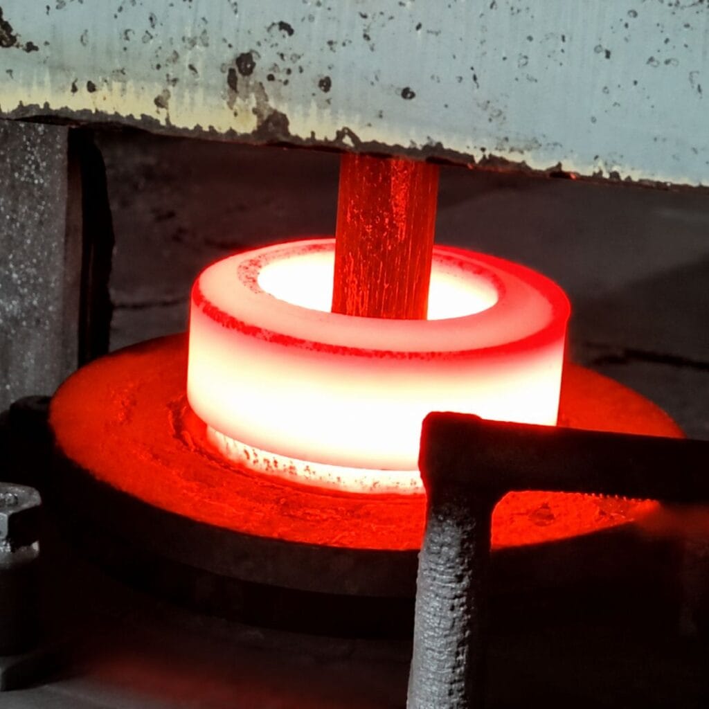 Heated steel billet inside a closed die forging tool illustrating forging tooling and die manufacturing for custom OEM forged components