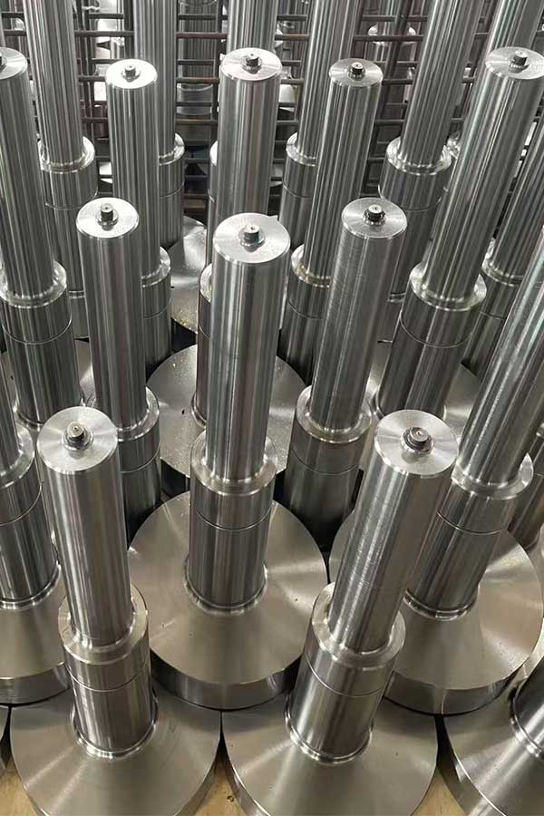 Batch of rough-machined forged steel shafts with turned journals and shoulders